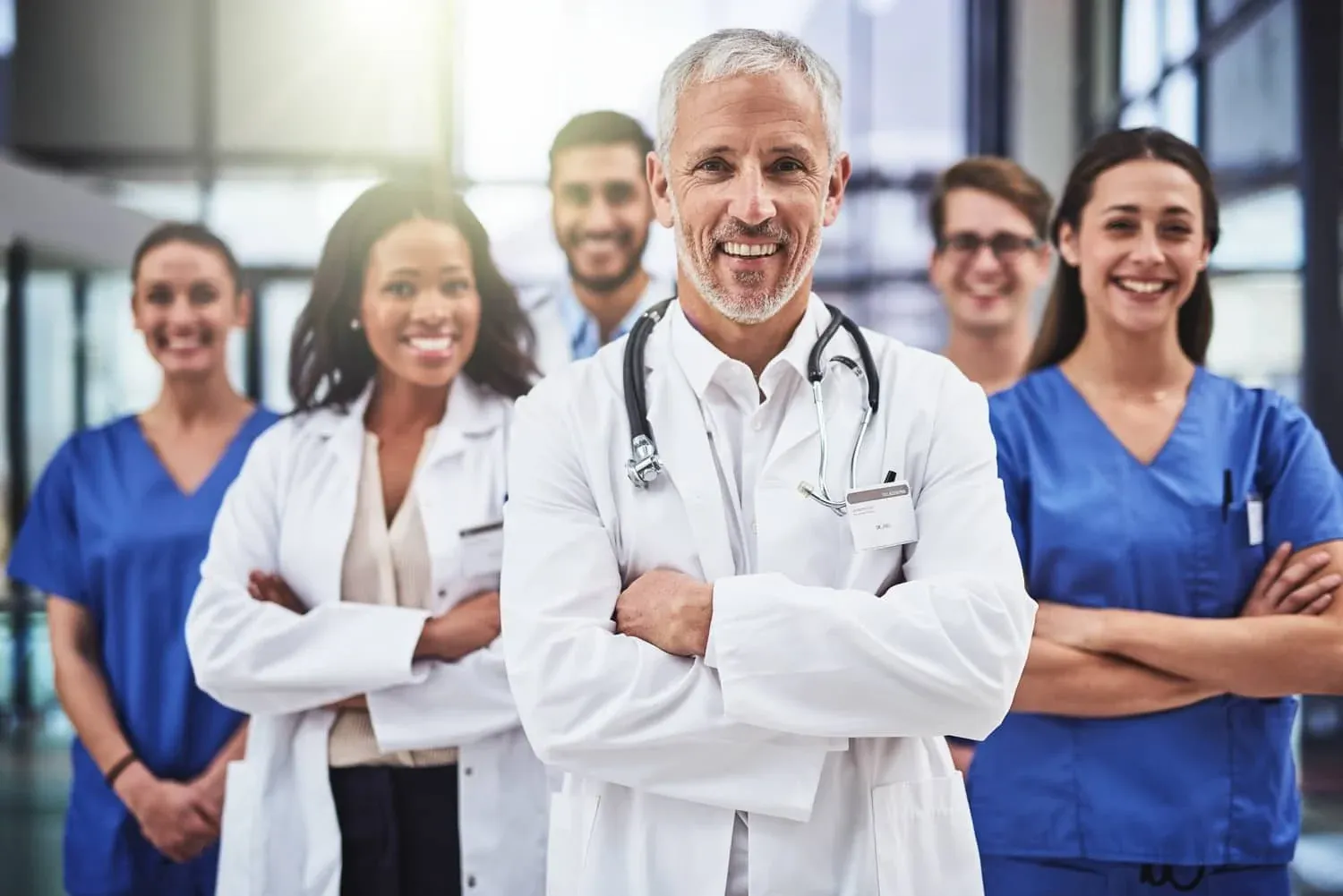 Equipo de médicos y profesionales de la salud sonriendo con los brazos cruzados