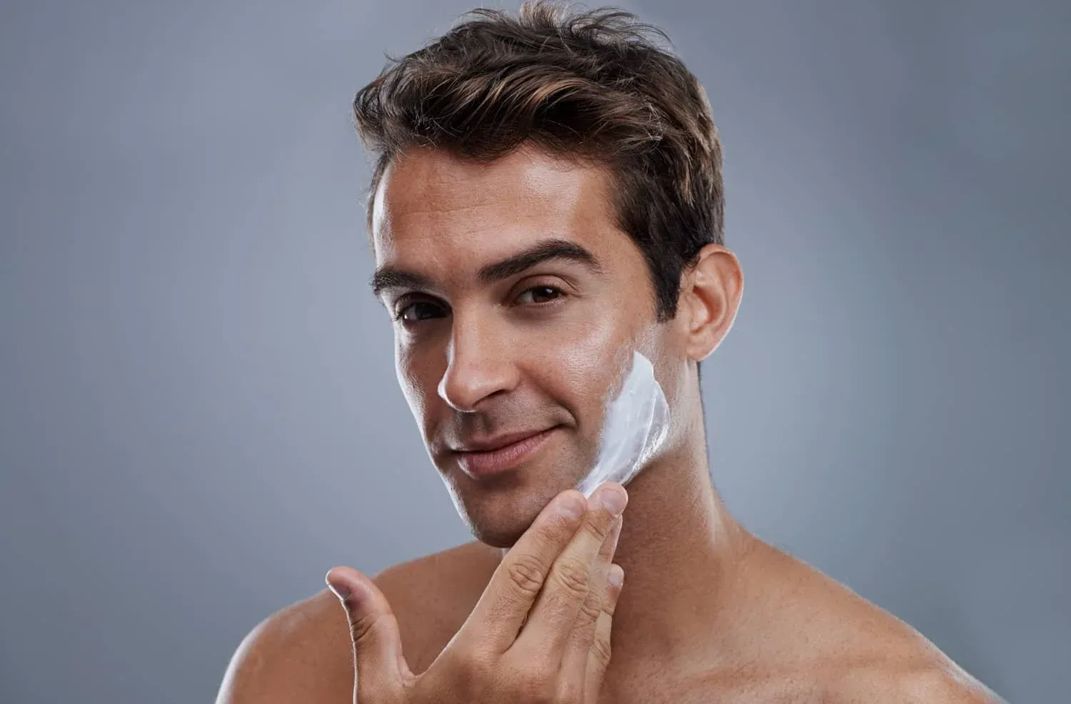 Hombre aplicando crema en la cara con los dedos